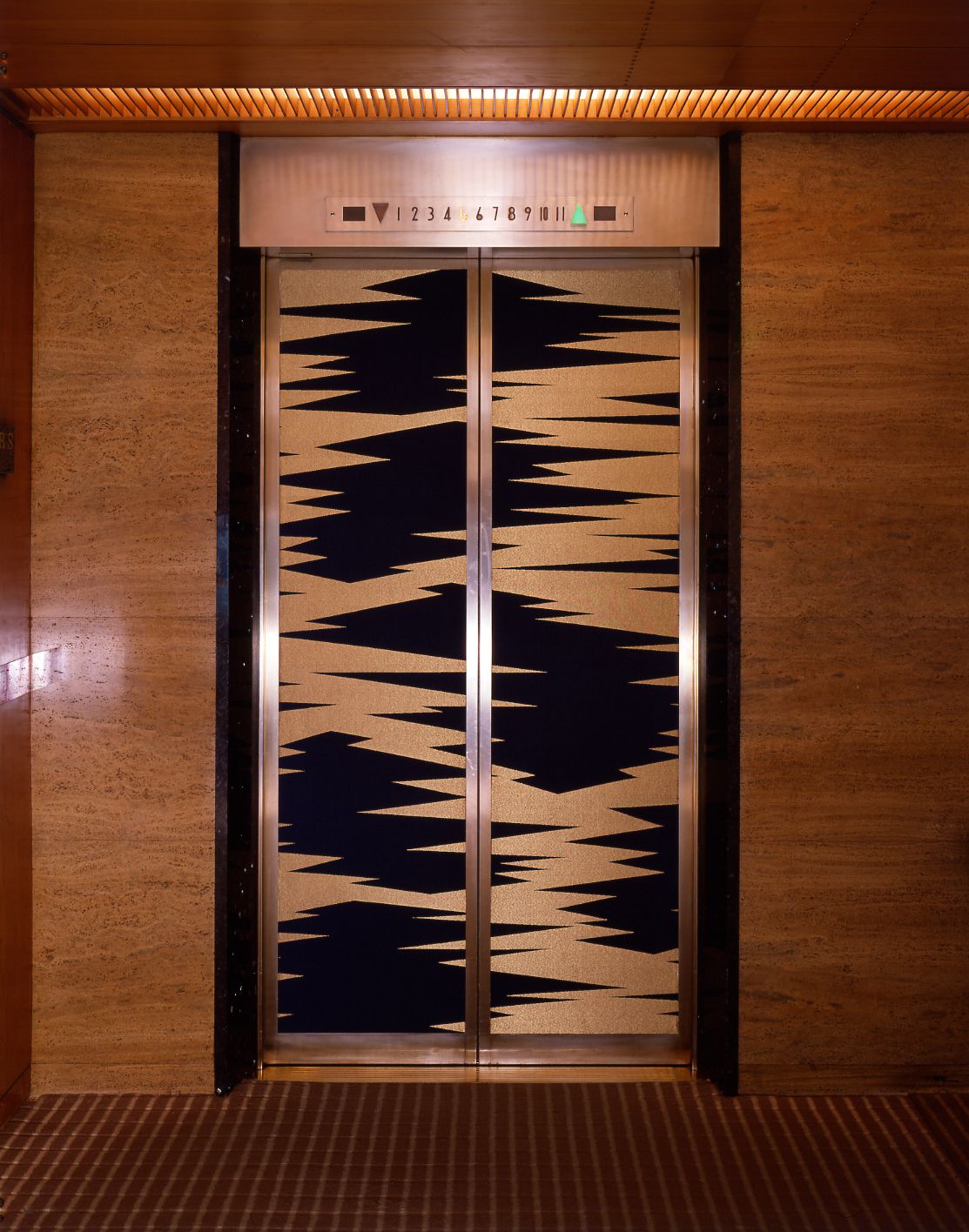 本館のエレべーターの扉は大倉家の家紋である「五階菱」をイメージした、菱くずし文様の錦張りが施されていた。