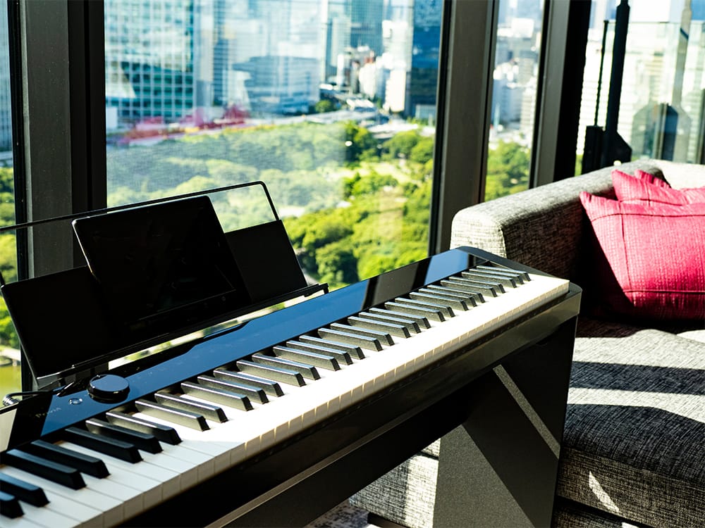 カシオのデジタルピアノPrivia PX-S1000BKを全客室に導入。グランドピアノのような鍵盤タッチを実現し、Bluetooth®スピーカーとしても使用可能。