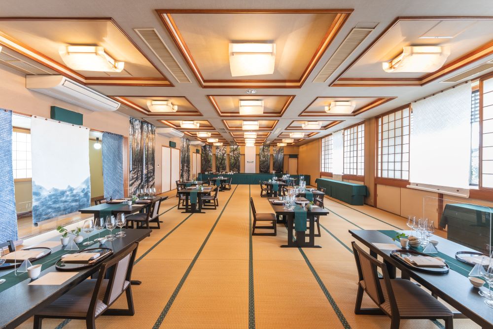 「松の井」の2階大広間を模様替え。唐津の松をイメージさせる深いグリーンを基調に、伝統の「名尾手すき和紙」や松林を映した巨大なスクリーンが下がる空間は、まさにレストラン。