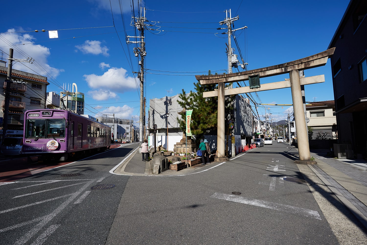 嵐電「蚕ノ社駅」付近は、道路上に線路が走る文字通りの路面電車スタイル。京都に残る唯一の路面電車区間だ。右手が「一の鳥居」。